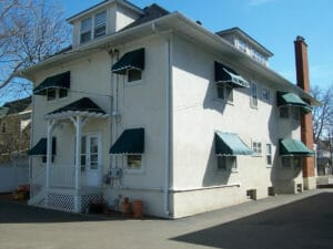 Traditional window awnings on two story home